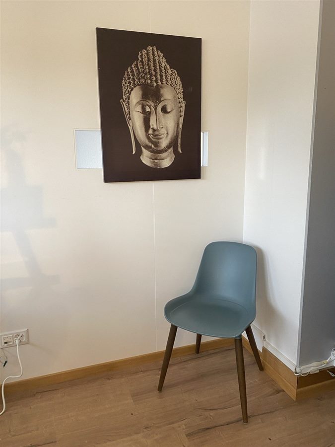 Sitzbereich mit beruhigendem Wandbild in der Praxis